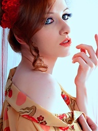 Redhead beauty stripping in white studio with red..